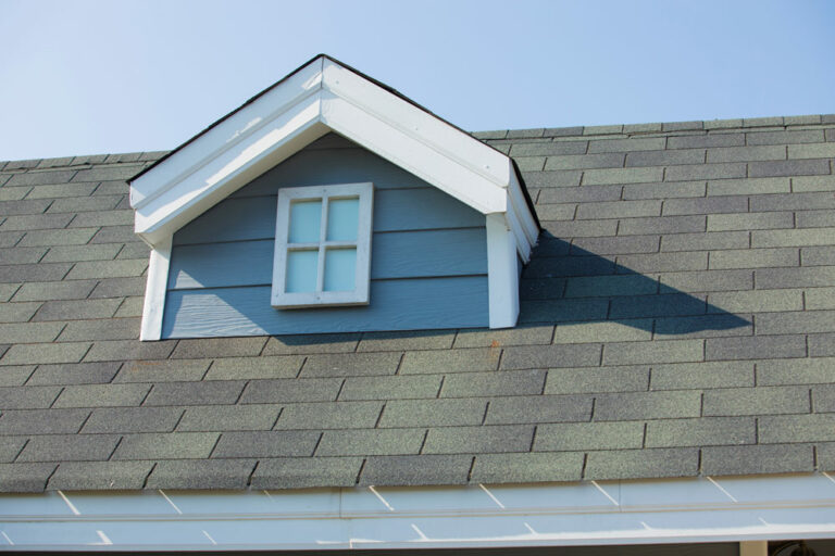 A house roof covered in asphalt shingle and a dormer gabled roof design