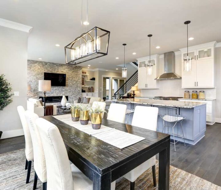 Beautiful kitchen in luxury modern contemporary home interior; a dining set, with cushioned chairs, hanging lights