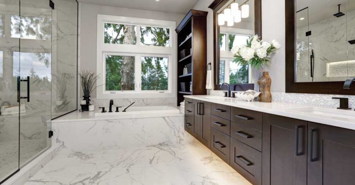 Master modern bathroom interior in luxury home with dark hardwood cabinets and shelves