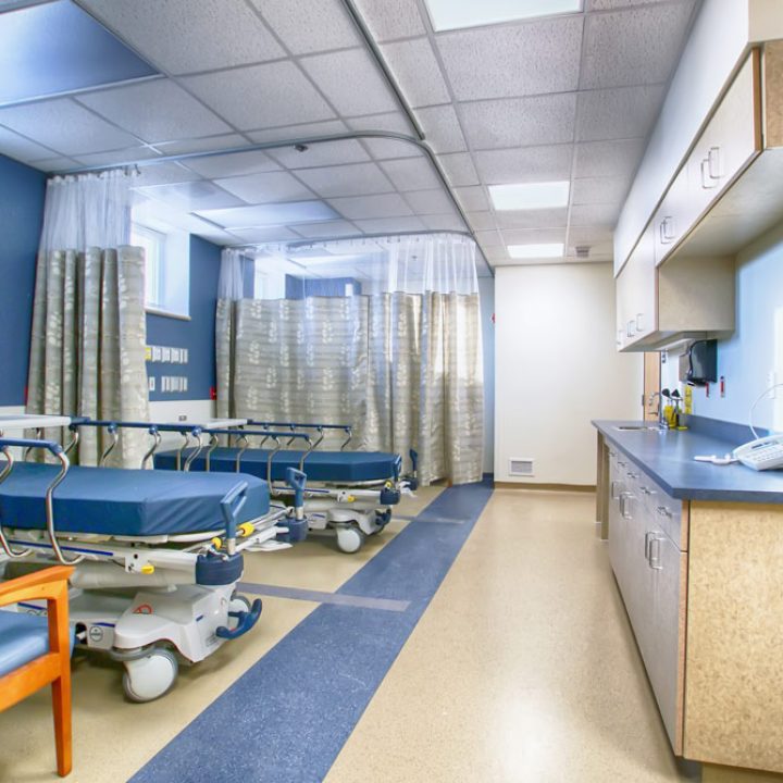 Emergency Room of a Hospital with beds, separated by curtains, and a reception countertop with phone set