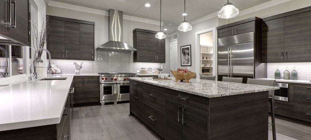 Modern gray kitchen features dark gray flat front cabinets paired with white quartz countertops and a glossy gray linear tile backsplash